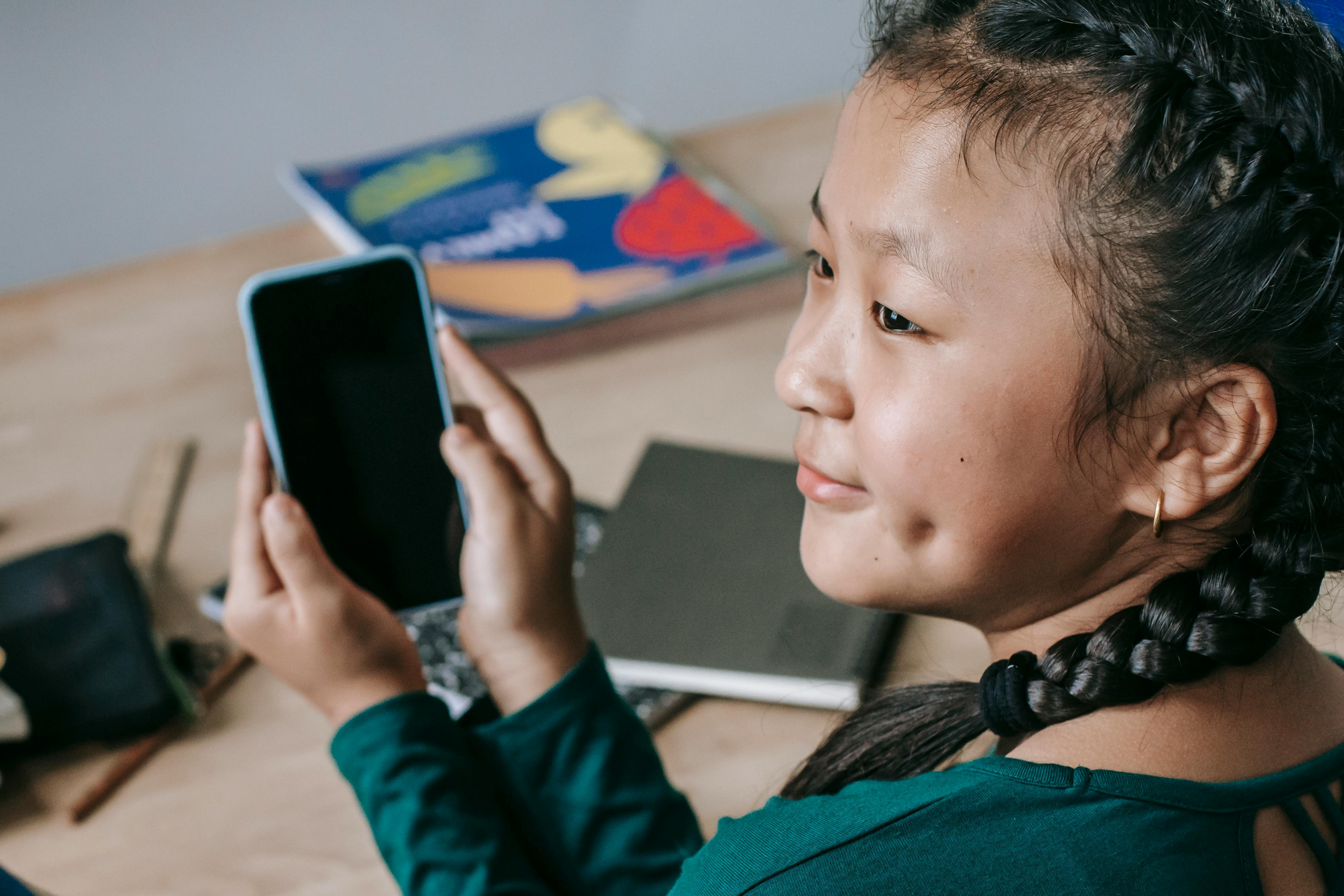 School pupil on a smartphone showing the importance of online safety awareness